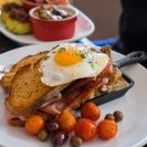 Creamed mushrooms with sunny side egg,  bacon,  roasted cherry tomatoes,  olives and rye toast (AU$18.50)