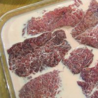In a large baking dish, lay out your steaks and pour one cup of milk over them. Let them rest for four hours covered in the refrigerator.